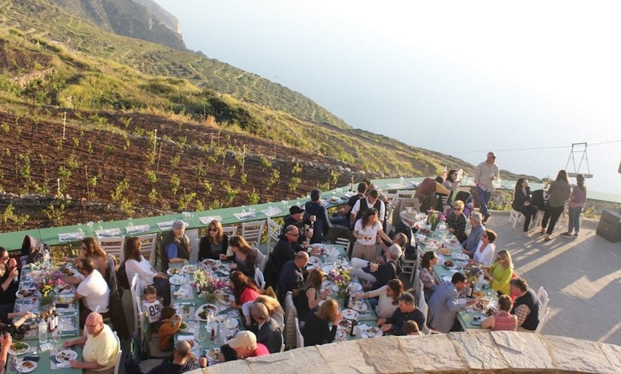 tourists sitting on the tables and enjoy a wine tasting and food at 'Manalis Winery' terrace